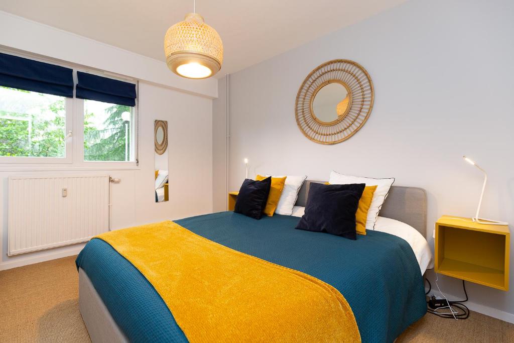 Un dormitorio con una cama grande con una manta amarilla y azul. en Le petit Barclay - Appartement privé de 45 m2 - 2 a 4 personnes - Parking gratuit, en Metz
