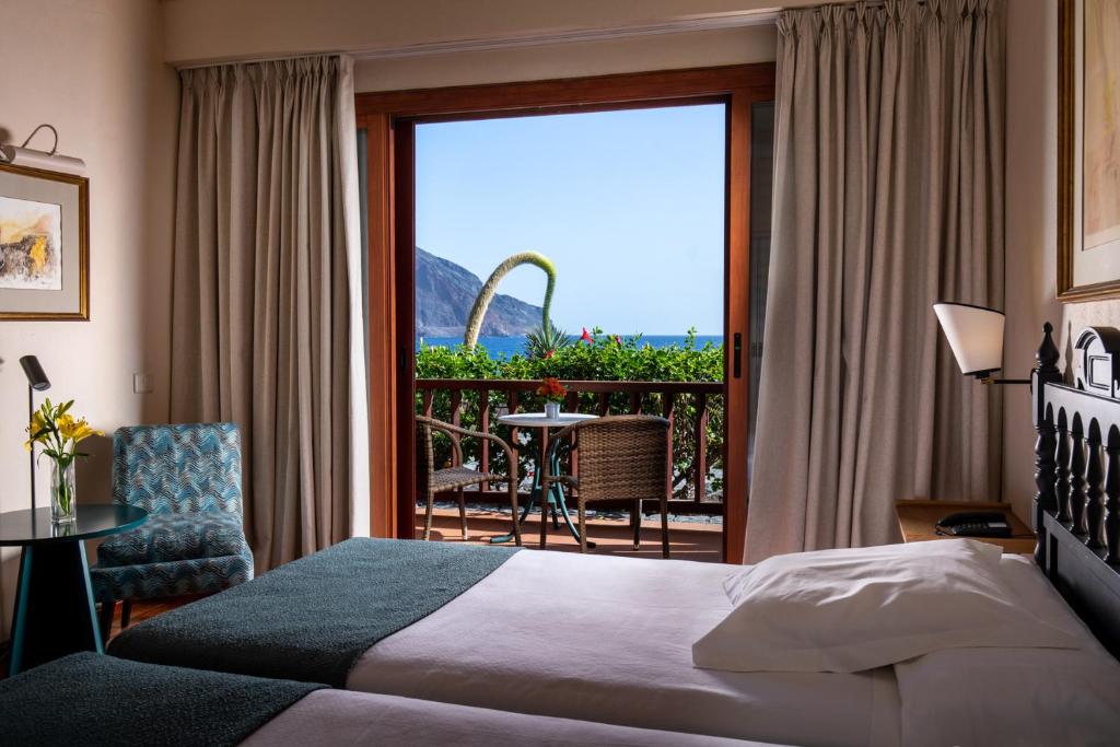 a hotel room with a bed and a balcony at Parador de El Hierro in Las Casas