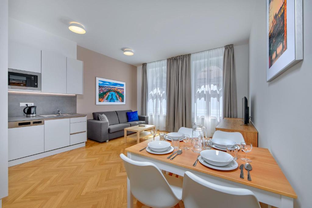 Una cocina y una sala de estar con mesa y sillas. en Downtown Suites Kodanska, en Praga