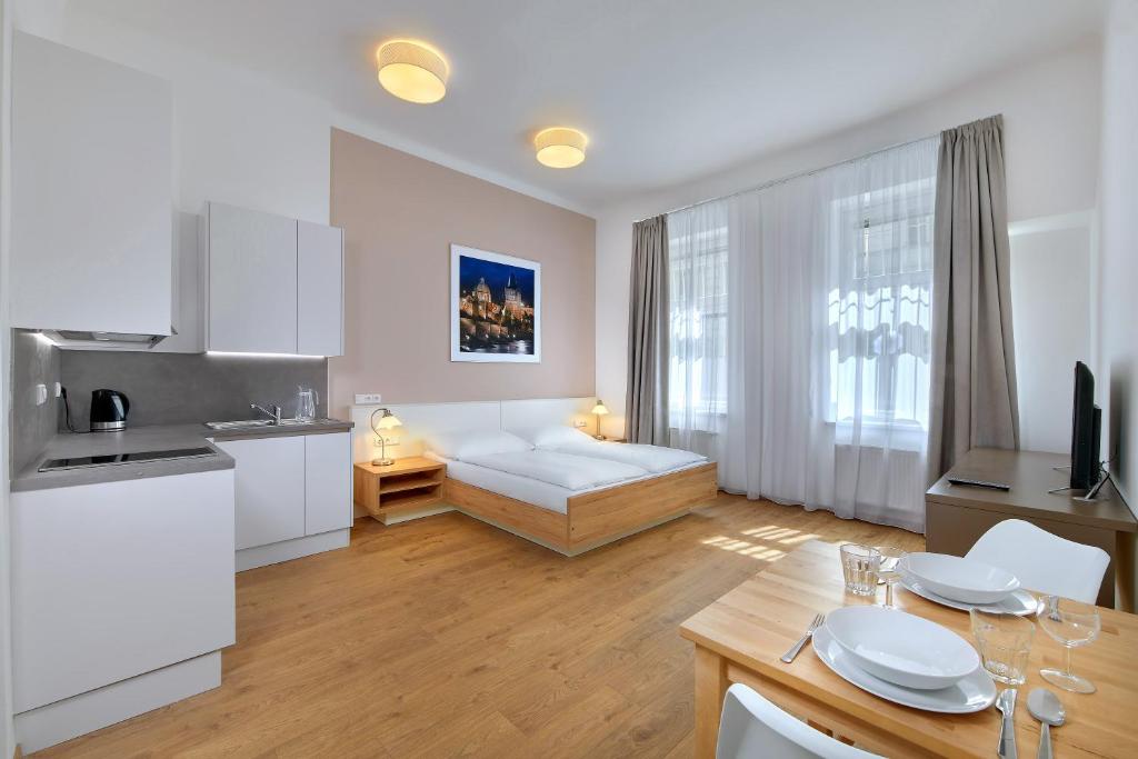 a kitchen with a white refrigerator and a white sink at Downtown Suites Kodanska in Prague
