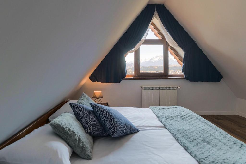a bedroom with a bed with a large window at Apartament na Szczycie in Bukowina Tatrzańska