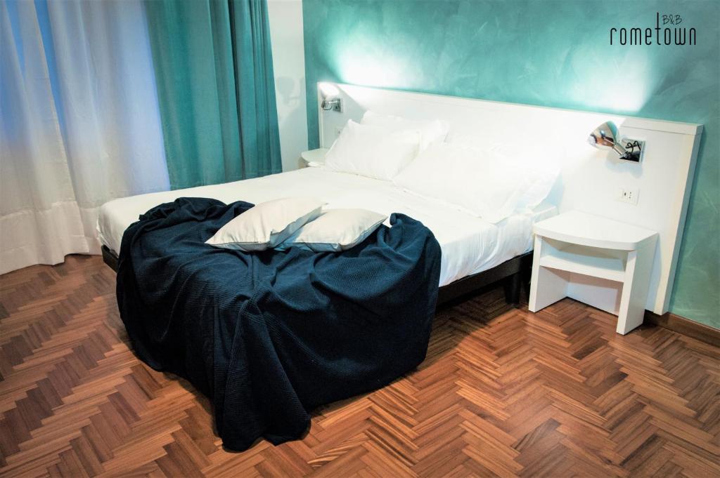 a bedroom with a large bed and a table at RomeTown B&B in Rome