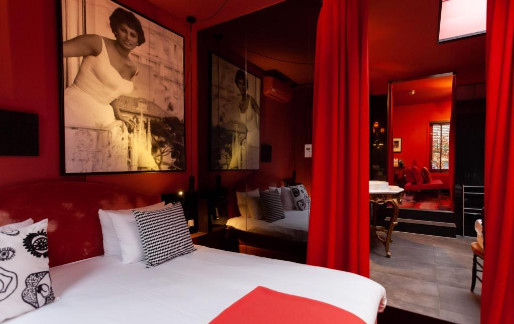 een slaapkamer met rode gordijnen en een bed in een kamer bij Boutiquehotel Staats in Haarlem