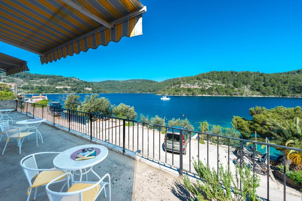 een balkon met uitzicht op een waterlichaam bij Guest House Radulj in Polače