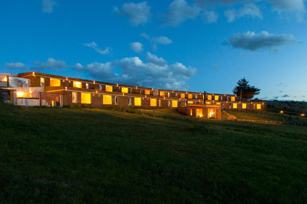 a large building on a field at night at Hotel Altiplanico Puerto Natales in Puerto Natales