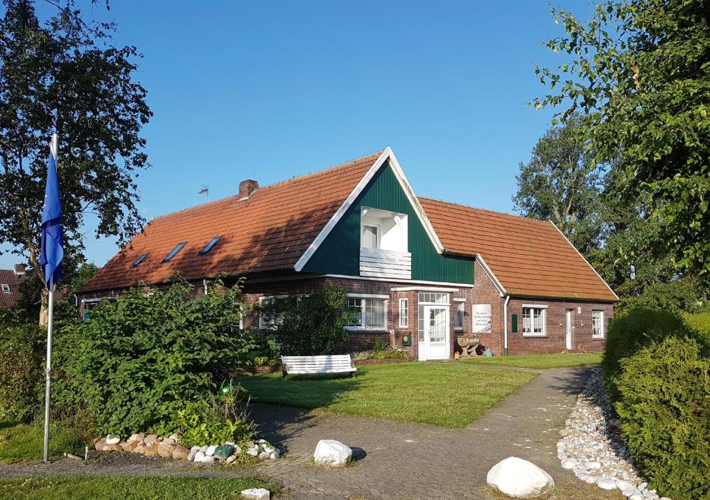 ein Haus mit einem roten und grünen Dach in der Unterkunft Birkenhof Neuharlingersiel in Neuharlingersiel