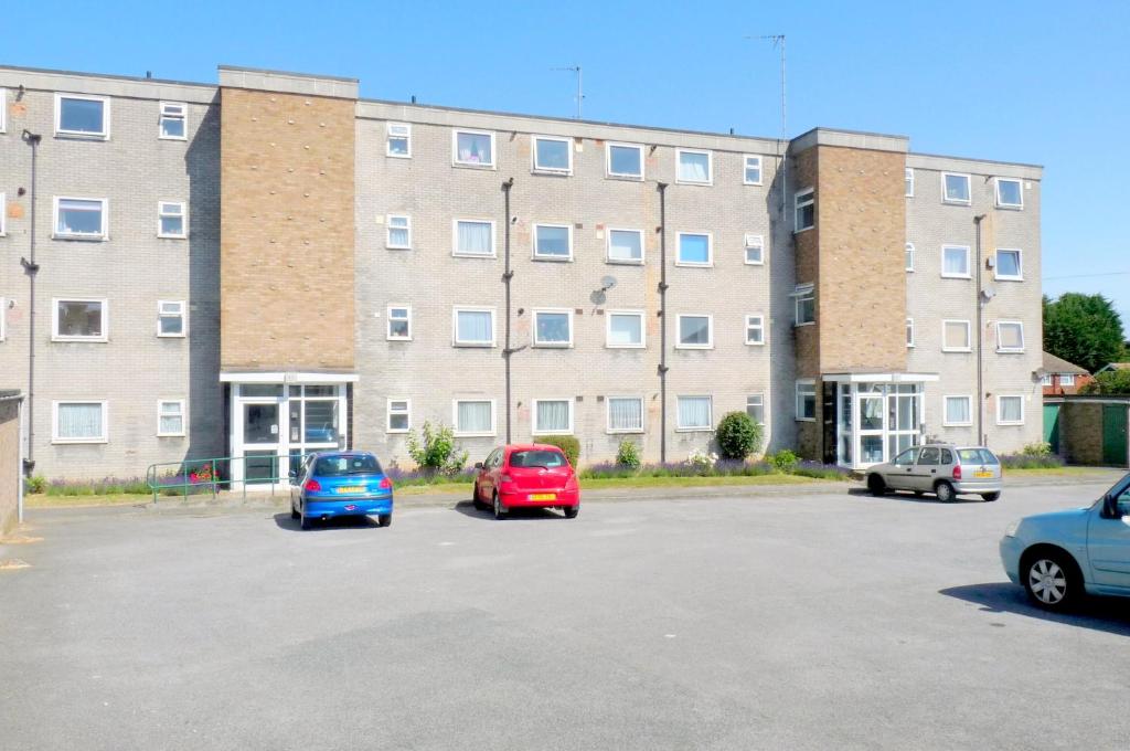 a group of cars parked in a parking lot in front of a building at Wentworth Apartment with 2 bedrooms, Superfast Wi-Fi and Parking in Sittingbourne