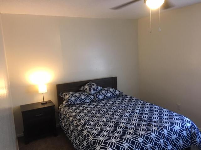 Fully furnished two bedroom apartment في لوتون: غرفة نوم بسرير لحاف ازرق وبيض