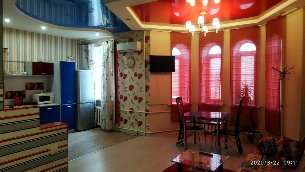 ザポリージャにある175 Sobornyi Studioのダイニングルーム(テーブル、椅子、赤い窓付)