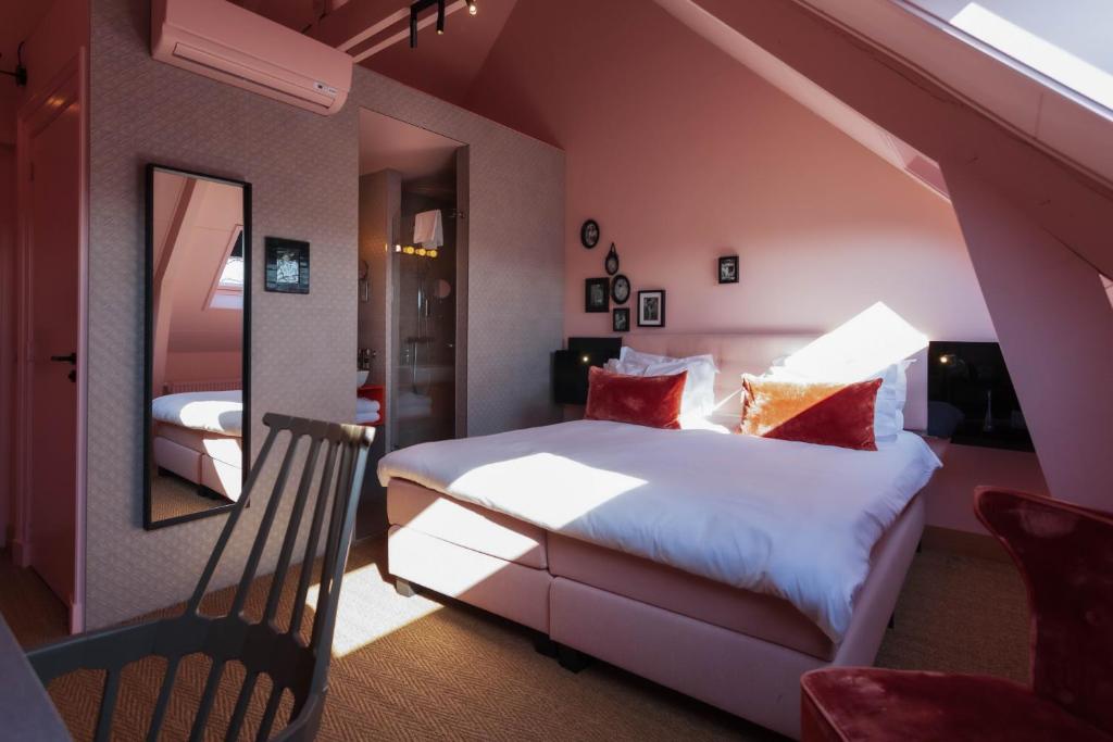 a room with a bed, chair and a window at Boutiquehotel Staats in Haarlem