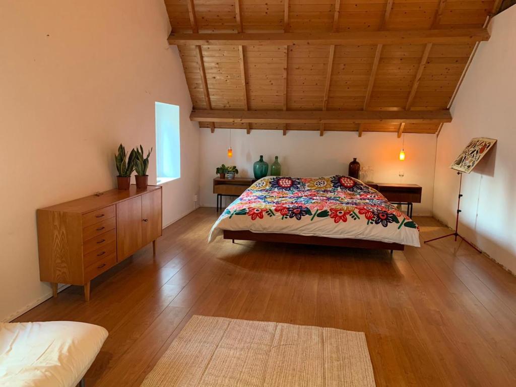 um quarto com uma cama e piso em madeira em Tanti Baci! em Maastricht