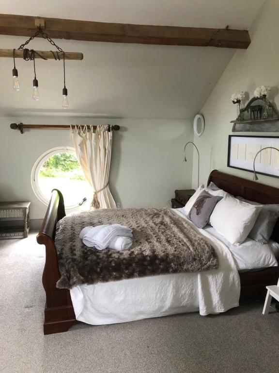 Un dormitorio con una cama grande y una ventana en The Jockey Room Hideaway, en Spurstow