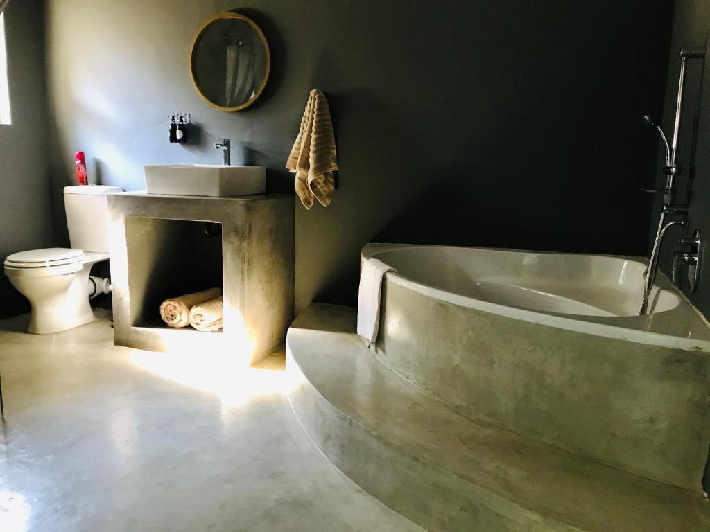 uma casa de banho com uma banheira, um lavatório e um WC. em Casa Cara Guest House em Parys