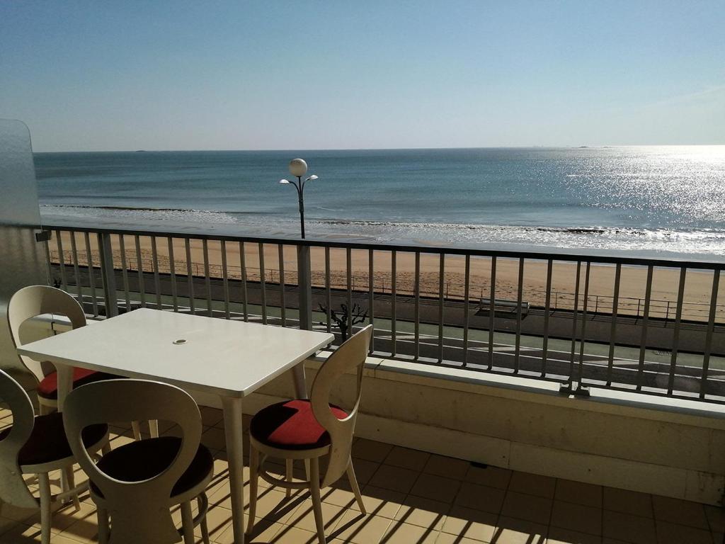 d'une table et de chaises sur un balcon donnant sur la plage. dans l'établissement Cap sur l'Océan pour 3 personnes, à La Baule