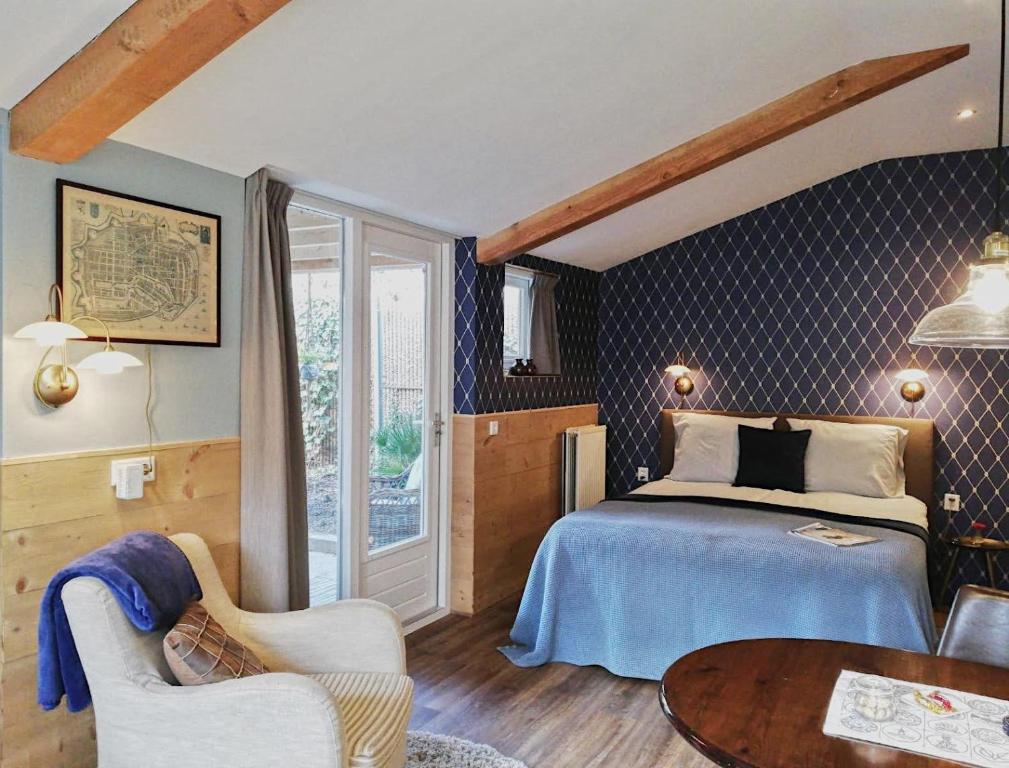 a bedroom with a bed and a table in a room at Casa Batavia B&B in Lelystad