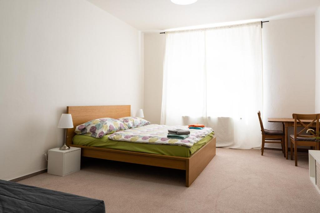 a bedroom with a bed and a large window at TopApartmany in Prague