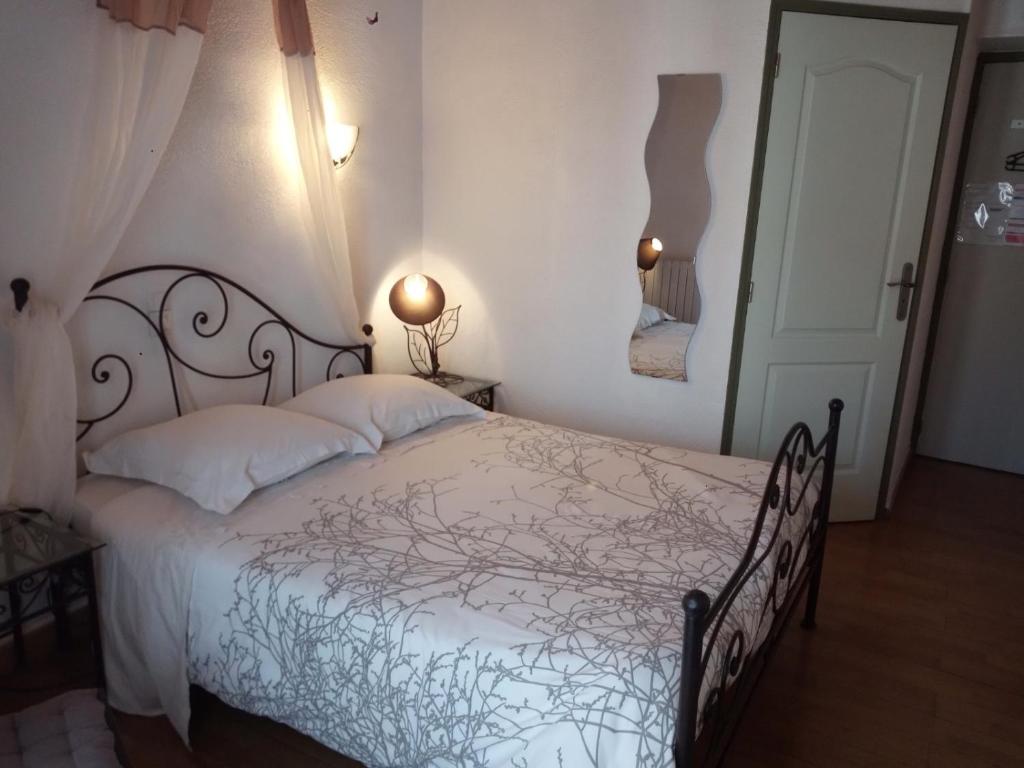 a bedroom with a bed with a white comforter at L&#39;Orangeraie in Elne