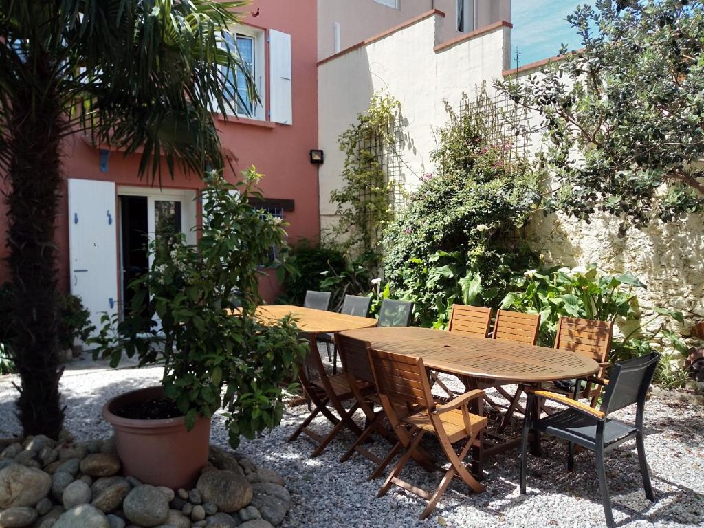 - une table et des chaises en bois dans le jardin dans l'établissement L'Orangeraie, à Elne