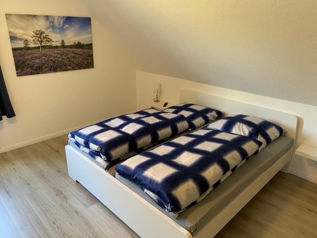 two beds in a room with a painting on the wall at Heidewohnung in Soltau