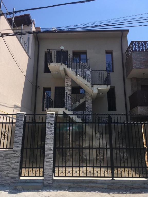 a house with a staircase in front of a fence at EUROPEAN HOUSE in Constanţa