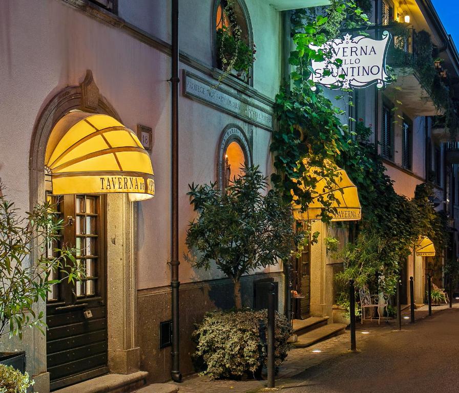 a building with a yellow awning on a street at Locanda dello Spuntino in Grottaferrata