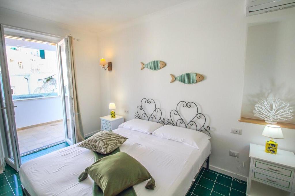a bedroom with a bed and a window with fish on the wall at Casa Pesce in Ponza