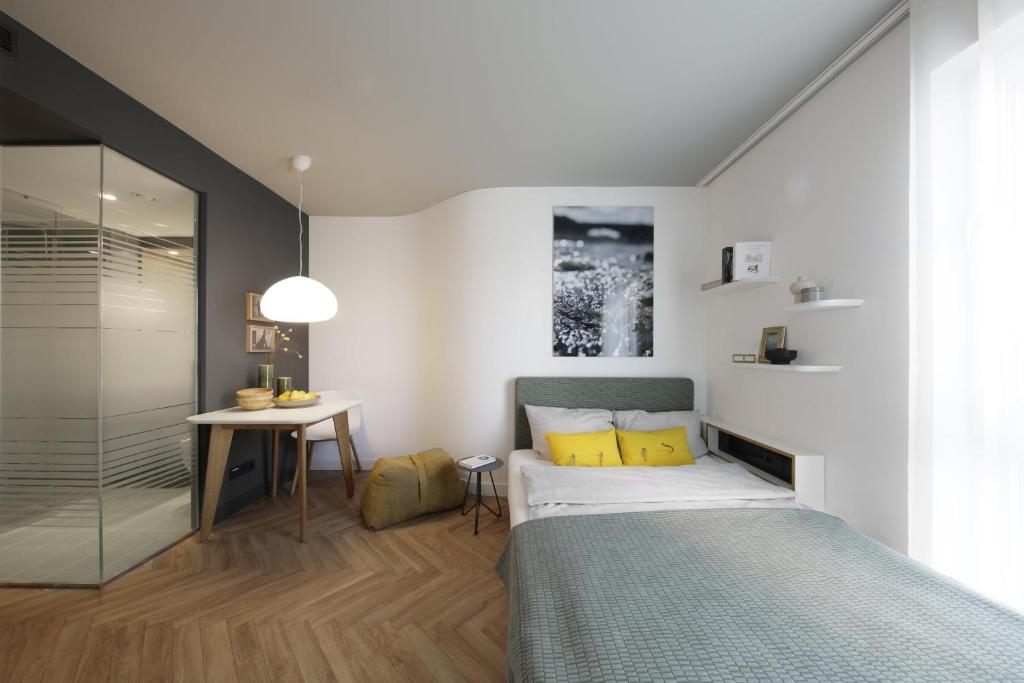 a small bedroom with a bed and a table at SMARTments business München Parkstadt Schwabing in Munich
