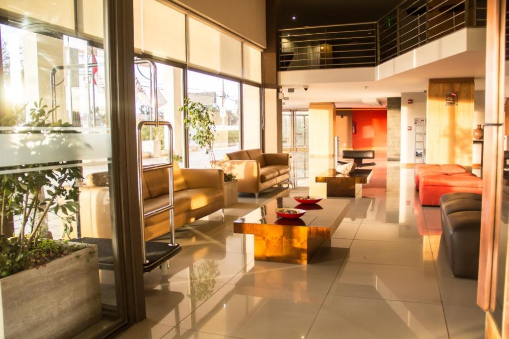 a lobby with couches and tables in a building at Alto del Sol Calama in Calama