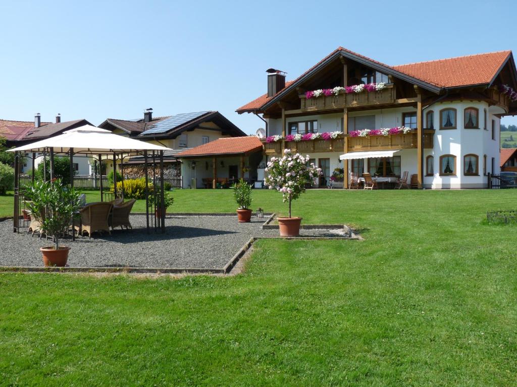 ein großes Haus mit Rasen davor in der Unterkunft Gästehaus "Zur Schmiede" in Wertach