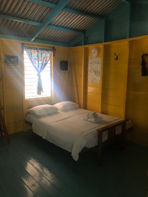 a bed in a room with a window at Colinda Cabanas in Caye Caulker