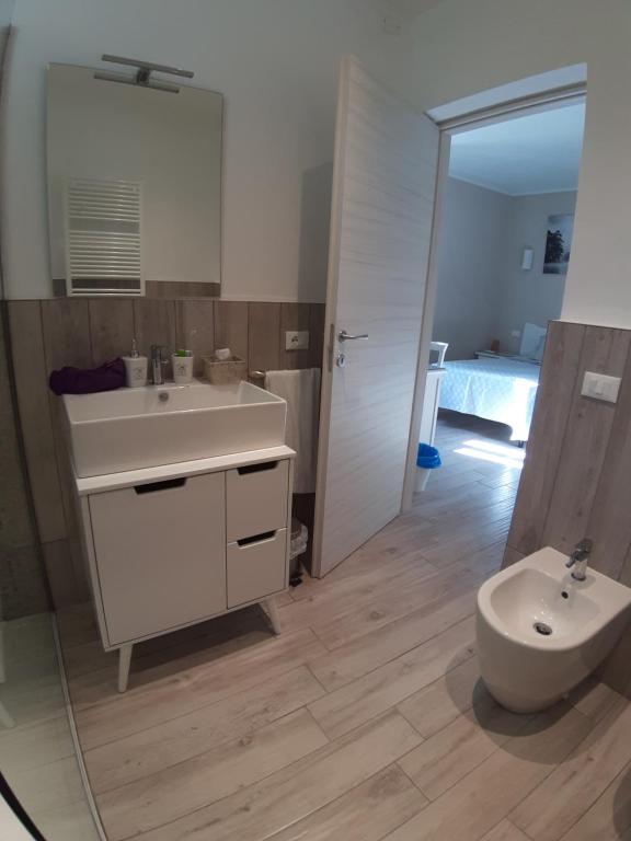 La salle de bains est pourvue d'un lavabo blanc et de toilettes. dans l'établissement Reggiolacittàinvisibile B&B, à Reggio d'Émilie