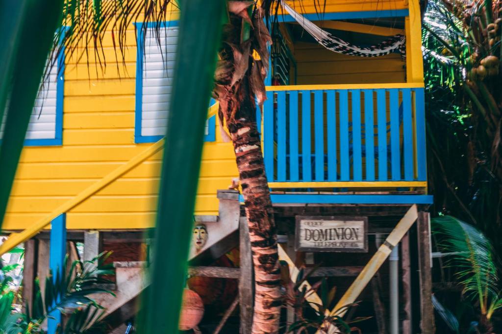 a yellow and blue house with a sign in front of it at Colinda Cabanas in Caye Caulker