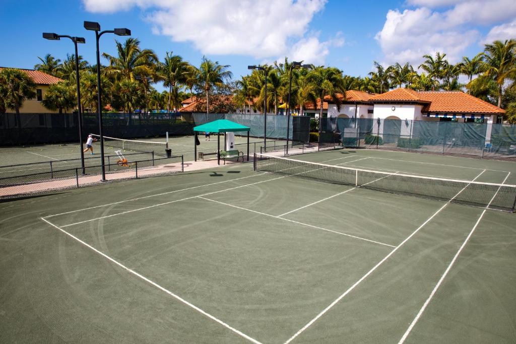 a tennis court with palm trees in the background at Naples Bay Resort and Marina in Naples