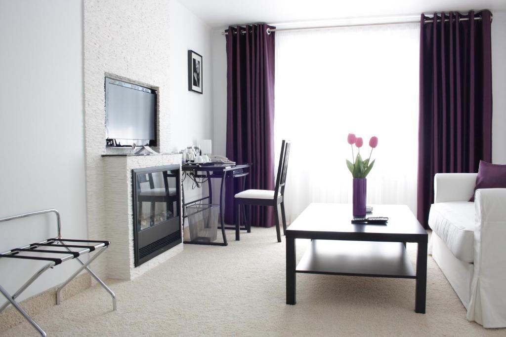 a living room with a white couch and a table at Yarhotel Centre in Yaroslavl