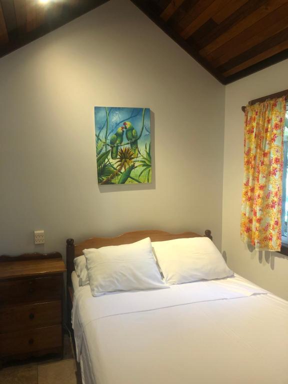 a bedroom with a bed and a picture on the wall at Colinda Cabanas in Caye Caulker
