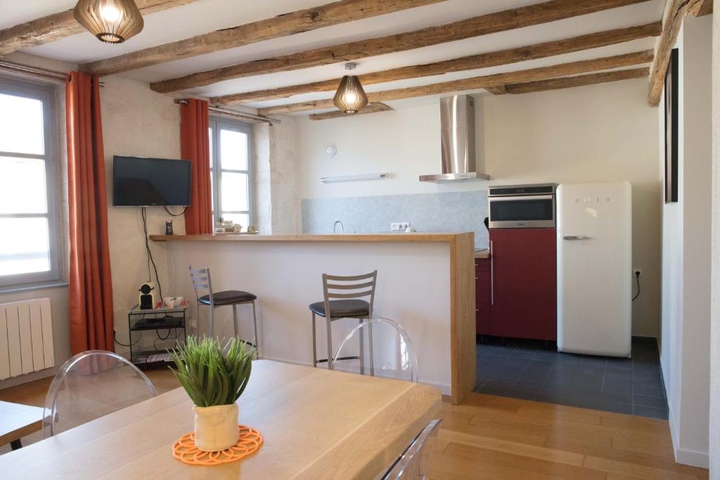 a kitchen with a table and chairs in a room at Appartement A-Mi-Chemin - Centre-ville de Tournus in Tournus