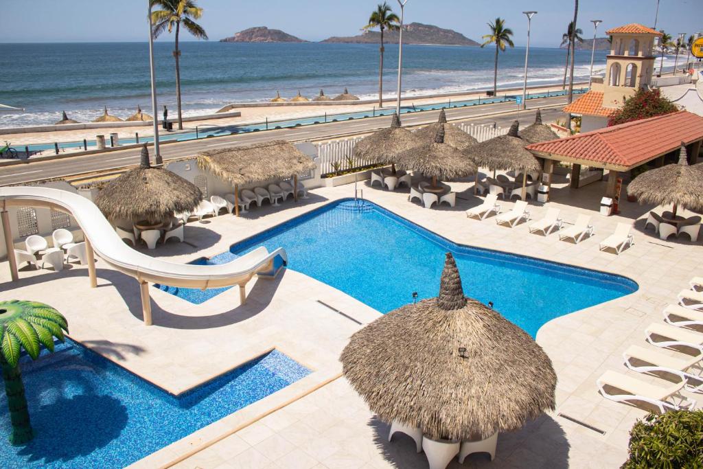 ośrodek z basenem, krzesłami i oceanem w obiekcie Hotel Sands Arenas w mieście Mazatlán