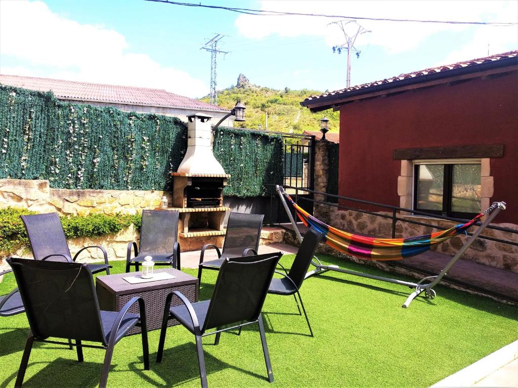 een patio met een hangmat en stoelen en een huis bij Casa Rural Madera y Sal in Salinas de Añana