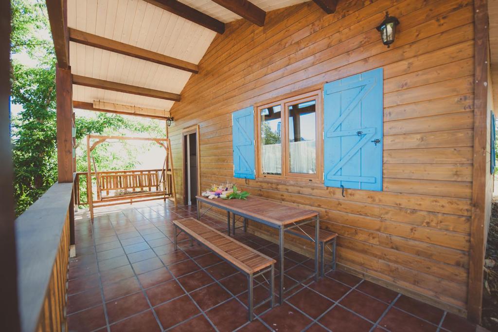 a wooden cabin with a bench on a porch at La Brizna "La tocas y te mueve" in Cañamero