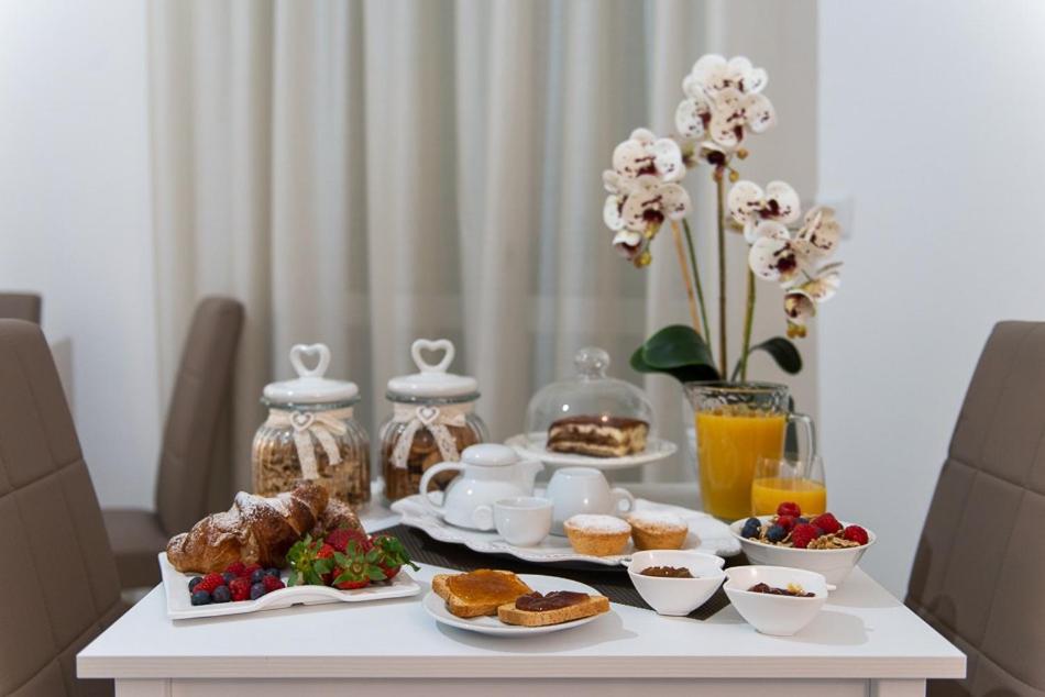 una mesa con comida para el desayuno y bebidas en ella en B.&.B Maison La Dama, en Maruggio