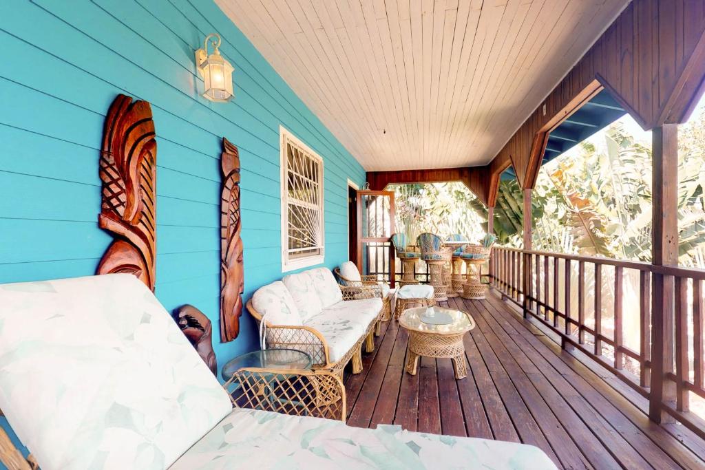 een veranda met een bank en stoelen op een terras bij Seaview at Casa Edie in Placencia Village