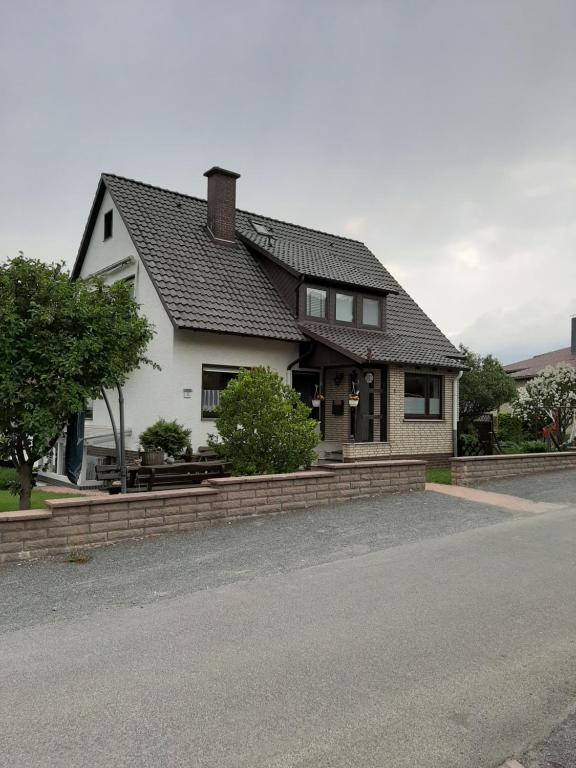 una casa blanca con techo negro en una calle en Familienfreundliche Ferienwohnung auf dem Lande Monteur Wohnung, en Hessisch Oldendorf