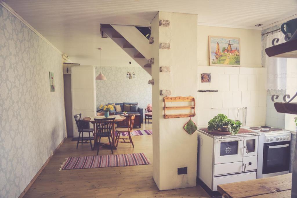 a kitchen with a stove and a table with chairs at Kärdla Retrovisiit Helmi in Kärdla