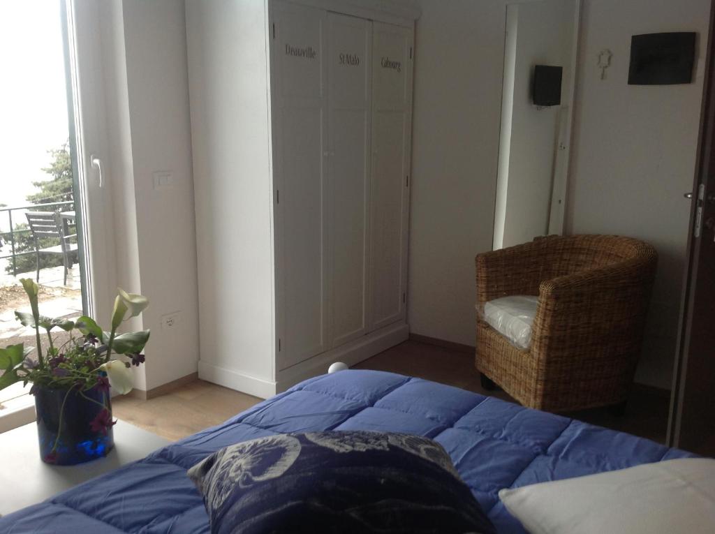 a bedroom with a bed and a chair and a window at Corte Del Gallo in Corniglia
