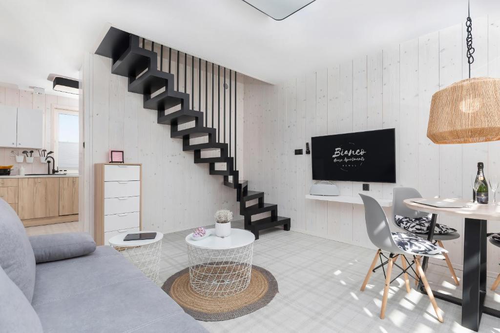 a living room with a staircase and a table at Bianco House Apartments in Rewal