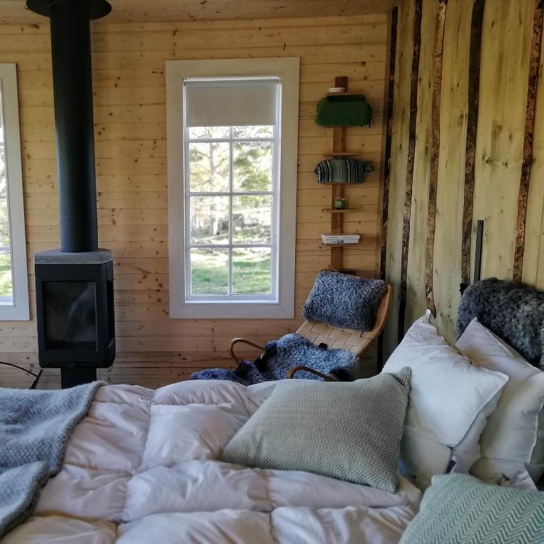 a bedroom with a bed and a stove at Eremitstuga Detox resort in Köpmannebro