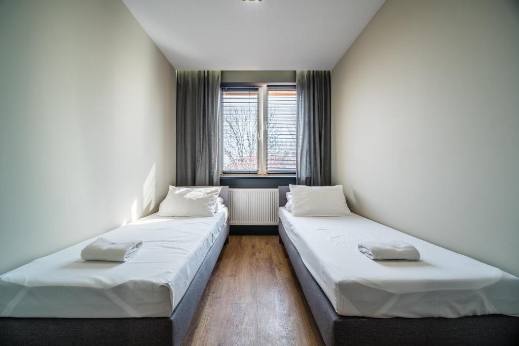 2 camas en una habitación pequeña con ventana en Rint - Centrum Zamenhofa Street, en Białystok