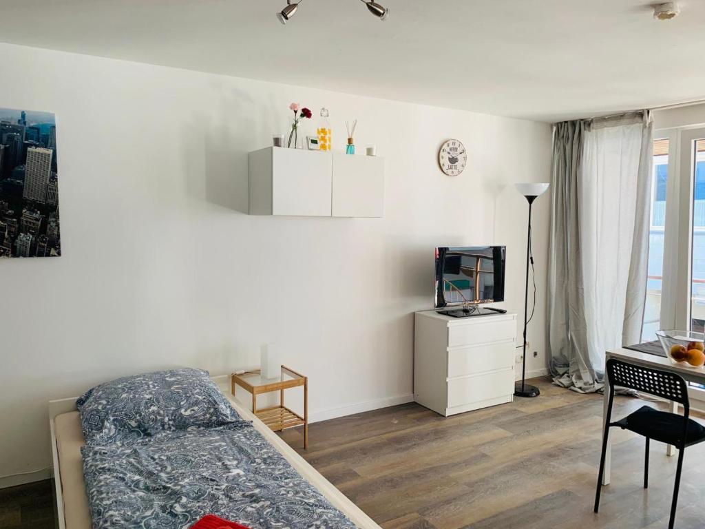 um quarto com uma cama, uma televisão e uma secretária em Kleine Wohnung im Herzen von Leverkusen Opladen em Leverkusen