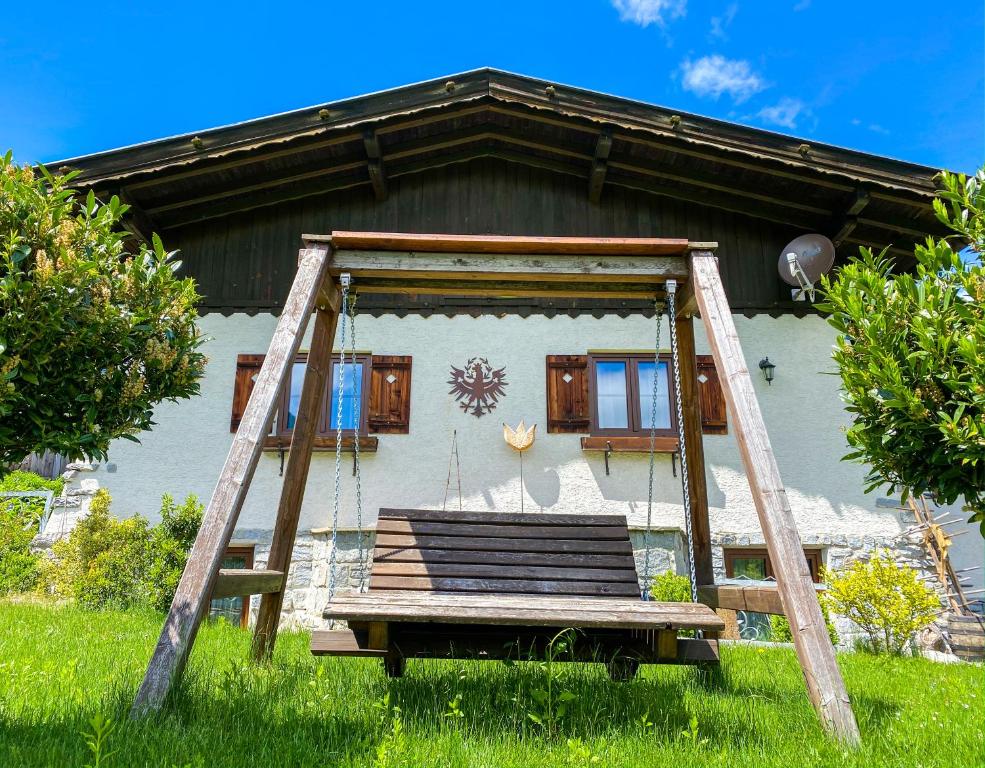 a swing in front of a house at Ferienhaus Ötztal-Lodge in Sautens