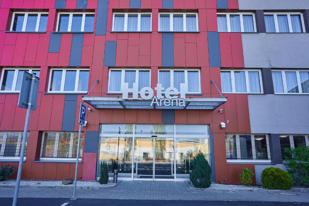 un edificio rojo con un signo de agente del hotel en él en Hotel Arena en Chomutov